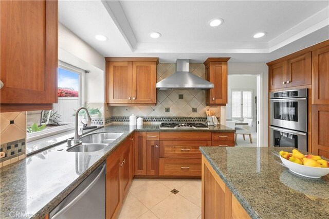 10 Cedarlake Unit 4, Irvine, CA 92614 - kitchen with a tray ceiling, wall chimney range hood, stainless steel appliances, and a sink
