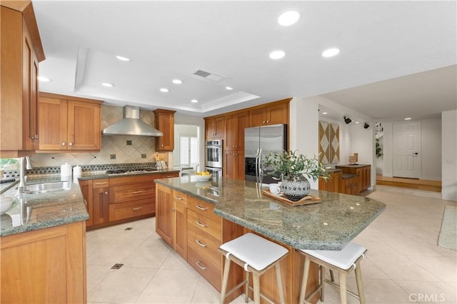 10 Cedarlake Unit 4, Irvine, CA 92614 - kitchen with wall chimney exhaust hood, a tray ceiling, a sink, visible vents, and appliances with stainless steel finishes