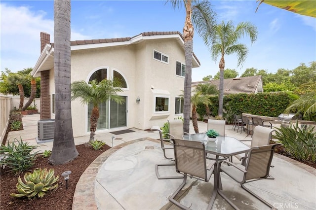 10 Cedarlake Unit 4, Irvine, CA 92614 - rear view of property featuring a patio area, outdoor dining area, central AC, and stucco siding