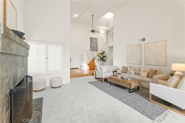 10 Cedarlake Unit 4, Irvine, CA 92614 - carpeted living room with ceiling fan, visible vents, high vaulted ceiling, and stairway