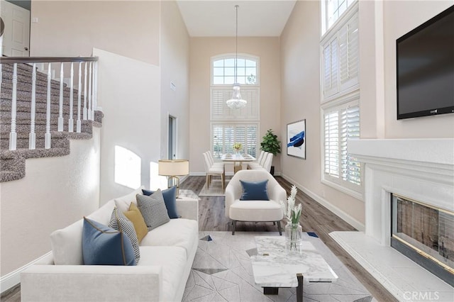429 Somerset Cir, Corona, CA 92879 - living area with a towering ceiling, stairway, baseboards, a glass covered fireplace, and wood finished floors