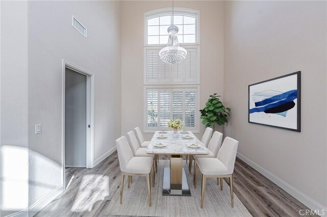 429 Somerset Cir, Corona, CA 92879 - dining room with a chandelier, wood finished floors, baseboards, and a towering ceiling
