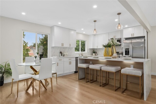 12635 Dorina Pl, Granada Hills, CA 91344 - kitchen with stainless steel appliances, decorative backsplash, a center island, white cabinets, and recessed lighting