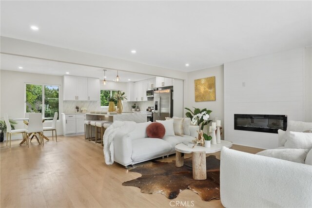 12635 Dorina Pl, Granada Hills, CA 91344 - living area featuring light wood-style floors, a glass covered fireplace, and recessed lighting