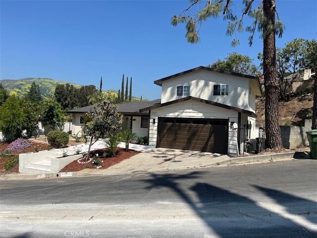 12635 Dorina Pl, Granada Hills, CA 91344 - view of front of house featuring concrete driveway, a garage, and a mountain view