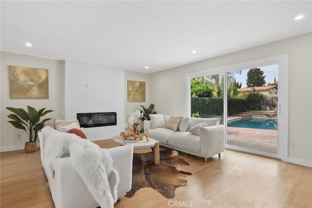 12635 Dorina Pl, Granada Hills, CA 91344 - living area featuring light wood-style flooring, recessed lighting, a large fireplace, and baseboards