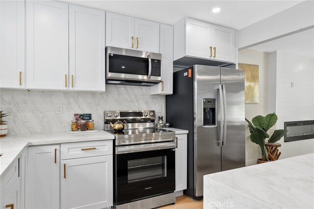 12635 Dorina Pl, Granada Hills, CA 91344 - kitchen featuring appliances with stainless steel finishes, white cabinets, backsplash, light stone countertops, and recessed lighting