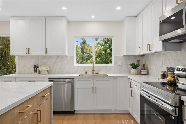 12635 Dorina Pl, Granada Hills, CA 91344 - kitchen featuring appliances with stainless steel finishes, a sink, light stone counters, white cabinetry, and recessed lighting