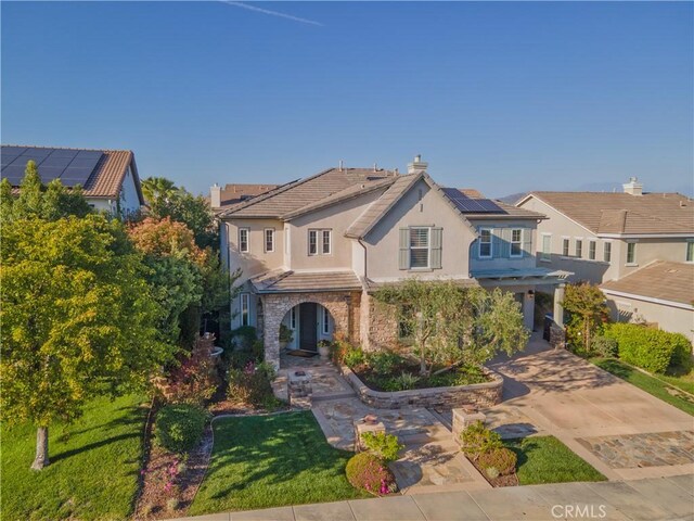 30304 Vercors St, Murrieta, CA 92563 - traditional home with a tile roof, stucco siding, roof mounted solar panels, a chimney, and stone siding