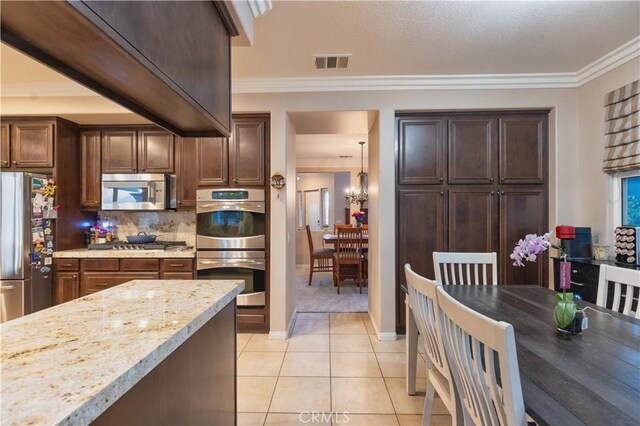 30304 Vercors St, Murrieta, CA 92563 - kitchen with stainless steel appliances, tasteful backsplash, crown molding, light tile patterned flooring, and baseboards