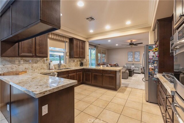 30304 Vercors St, Murrieta, CA 92563 - kitchen featuring a peninsula, open floor plan, crown molding, freestanding refrigerator, and dark brown cabinetry