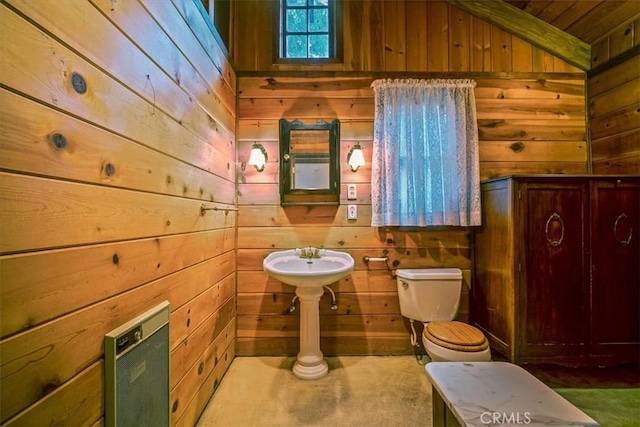 bathroom featuring wooden walls and toilet