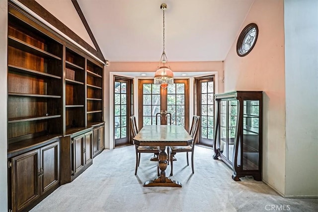 dining space featuring vaulted ceiling, light colored carpet, and french doors