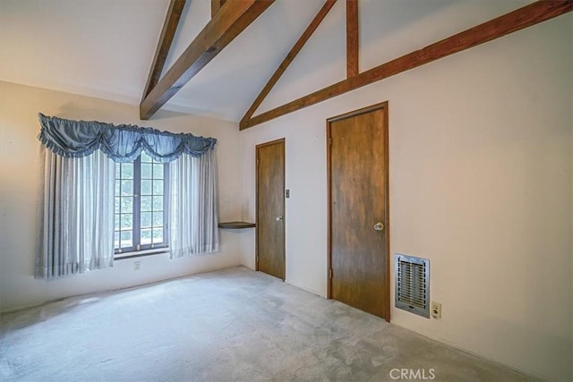 carpeted empty room with beamed ceiling, visible vents, and high vaulted ceiling