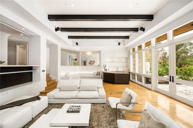 living room with beam ceiling and light wood-style flooring