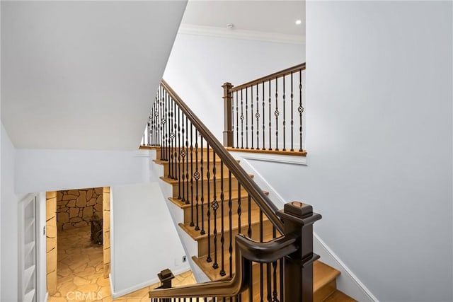 stairway with crown molding and baseboards