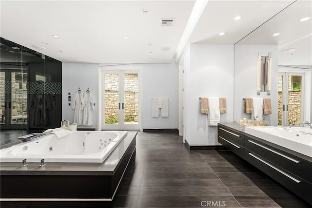 full bathroom featuring baseboards, visible vents, recessed lighting, a tub with jets, and vanity