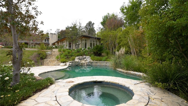 pool featuring stairs and an in ground hot tub