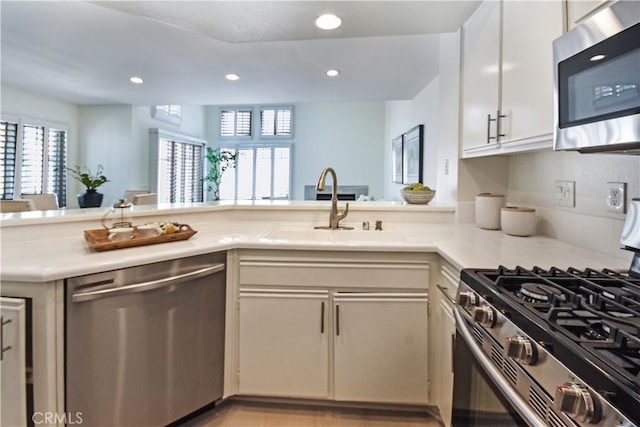 85 Briarglen, Irvine, CA 92614 - kitchen featuring stainless steel appliances, a sink, light countertops, recessed lighting, and a peninsula