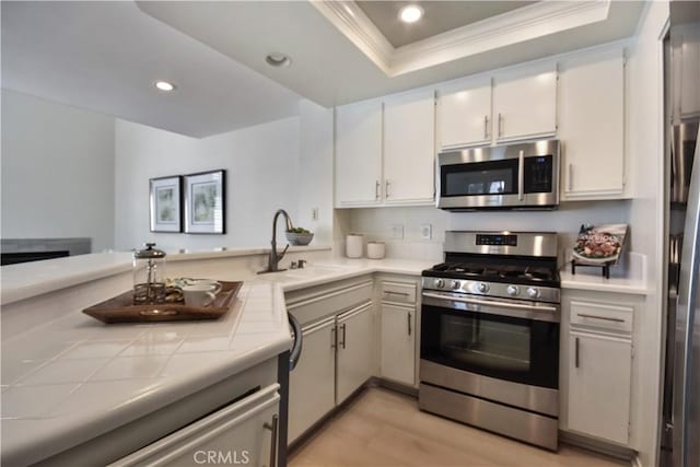85 Briarglen, Irvine, CA 92614 - kitchen with stainless steel appliances, tile counters, a sink, ornamental molding, and a tray ceiling