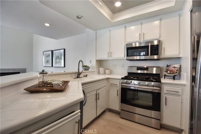 85 Briarglen, Irvine, CA 92614 - kitchen with stainless steel appliances, tile countertops, ornamental molding, a tray ceiling, and recessed lighting