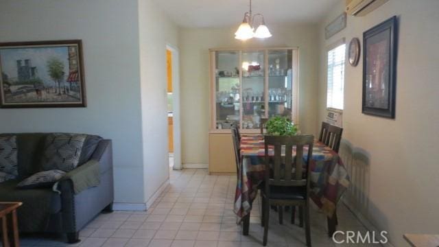 506 N Sunset Ave, Azusa, CA 91702 - dining space featuring a chandelier, a wall mounted AC, light tile patterned flooring, and baseboards