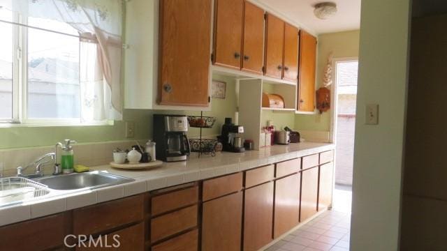 506 N Sunset Ave, Azusa, CA 91702 - kitchen with plenty of natural light, brown cabinets, a sink, and tile countertops