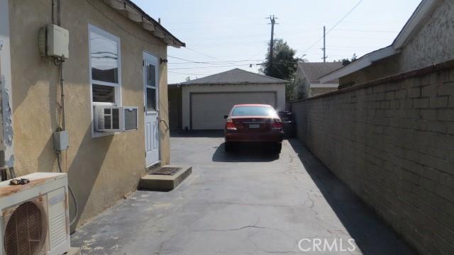 506 N Sunset Ave, Azusa, CA 91702 - view of side of home featuring ac unit, stucco siding, a garage, an outdoor structure, and fence