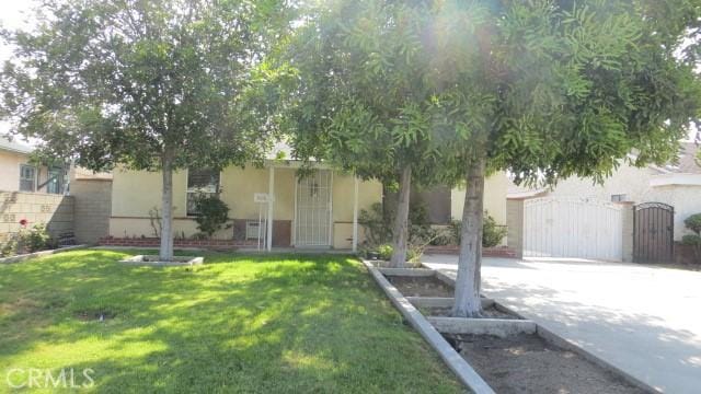 506 N Sunset Ave, Azusa, CA 91702 - view of property hidden behind natural elements featuring stucco siding, a gate, and concrete driveway