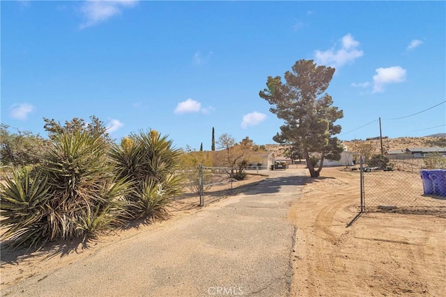 9415 Yucca St, Apple Valley, CA 92308 - view of street featuring aphalt driveway and a gated entry