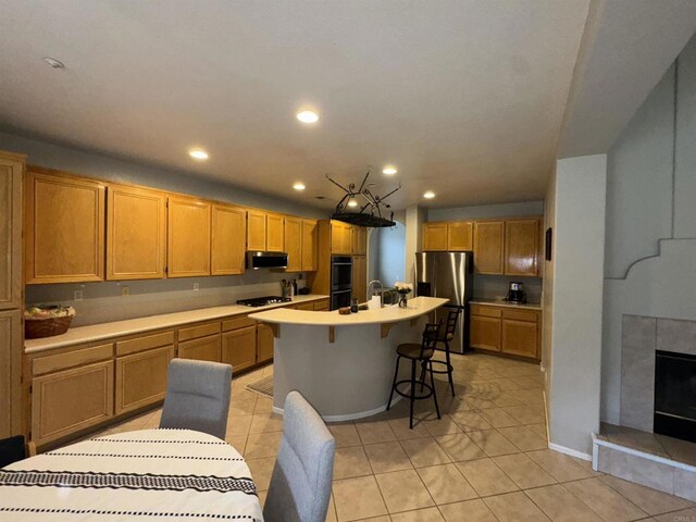 kitchen featuring a breakfast bar, light tile patterned floors, stainless steel appliances, light countertops, and recessed lighting
