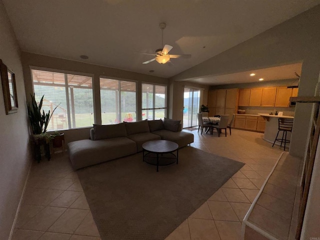 living room featuring ceiling fan, lofted ceiling, light tile patterned flooring, and plenty of natural light