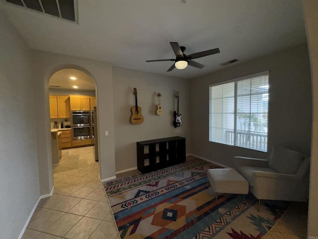 living room featuring arched walkways, visible vents, baseboards, and light tile patterned floors