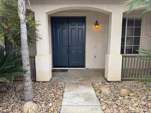 doorway to property featuring stucco siding