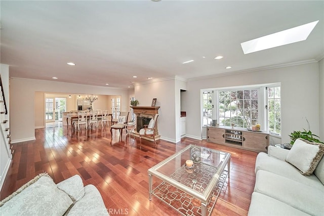 living area featuring ornamental molding, wood finished floors, and a healthy amount of sunlight