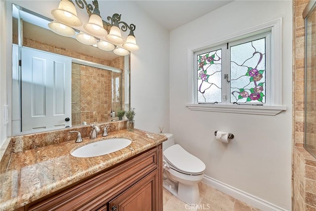 bathroom with vanity, toilet, tile patterned floors, baseboards, and tiled shower