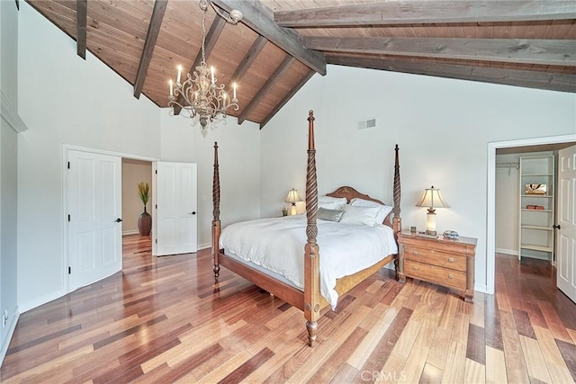 bedroom with visible vents, wooden ceiling, beamed ceiling, a chandelier, and light wood-style floors