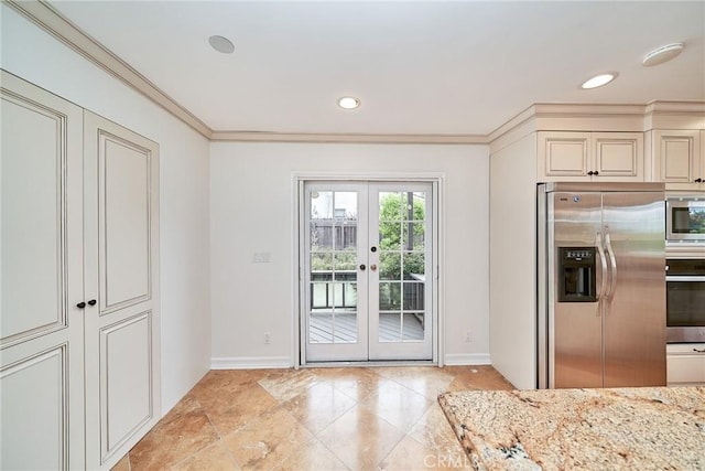 kitchen with french doors, baseboards, appliances with stainless steel finishes, and cream cabinetry