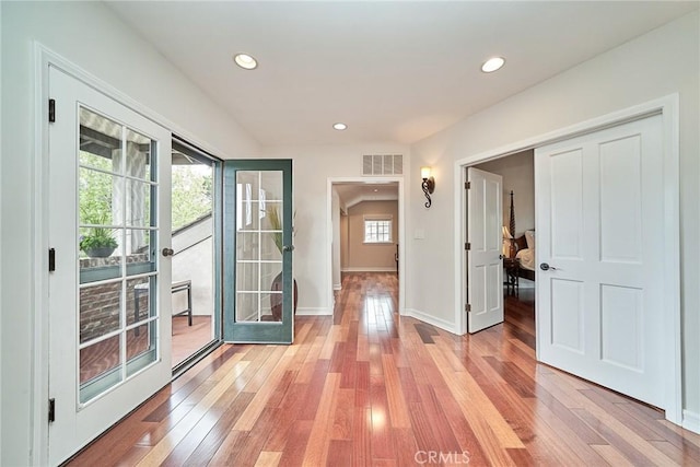 corridor featuring light wood-style floors, french doors, recessed lighting, and visible vents