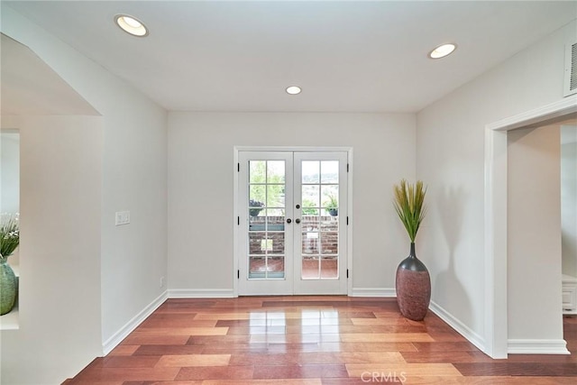 unfurnished room with baseboards, french doors, recessed lighting, and wood finished floors
