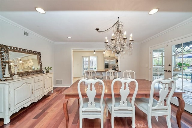 dining area with a healthy amount of sunlight, french doors, light wood-type flooring, and visible vents
