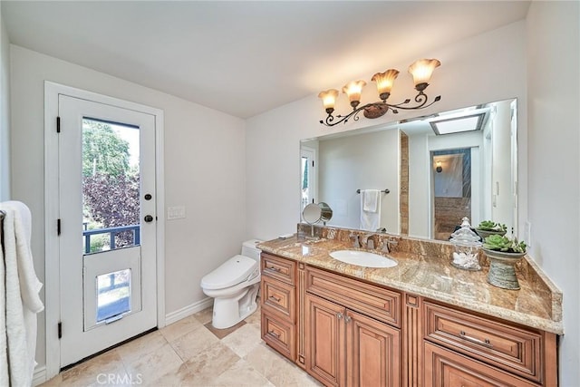 bathroom featuring vanity, baseboards, and toilet