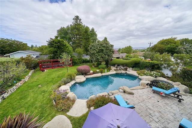 outdoor pool with a patio area and a yard