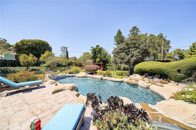 pool featuring fence and a patio area