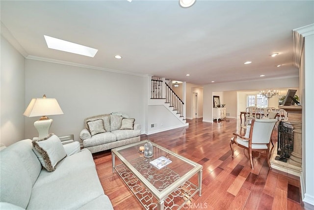 living room with ornamental molding, wood finished floors, a skylight, and stairway