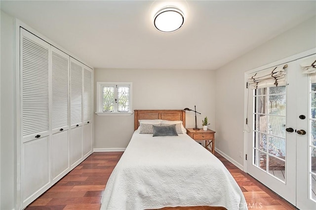 bedroom with baseboards, wood finished floors, a closet, and access to exterior