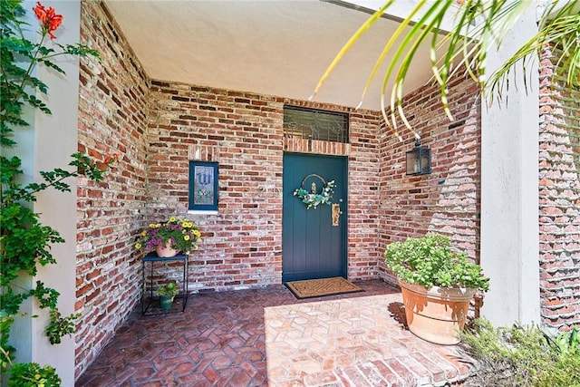 entrance to property featuring brick siding