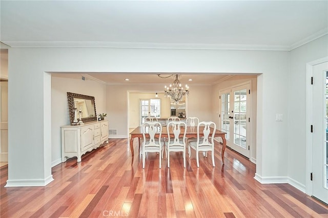 dining space featuring baseboards, ornamental molding, and light wood-style flooring