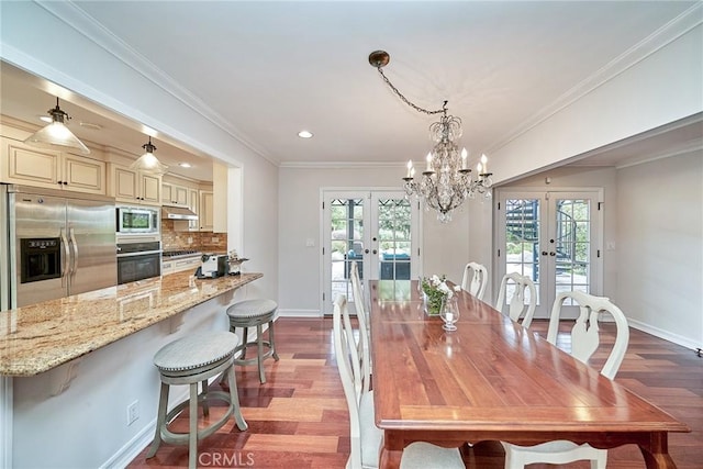 dining room featuring baseboards, a healthy amount of sunlight, french doors, and wood finished floors