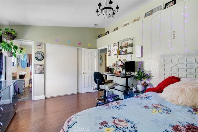 bedroom with wood finished floors, high vaulted ceiling, and an inviting chandelier